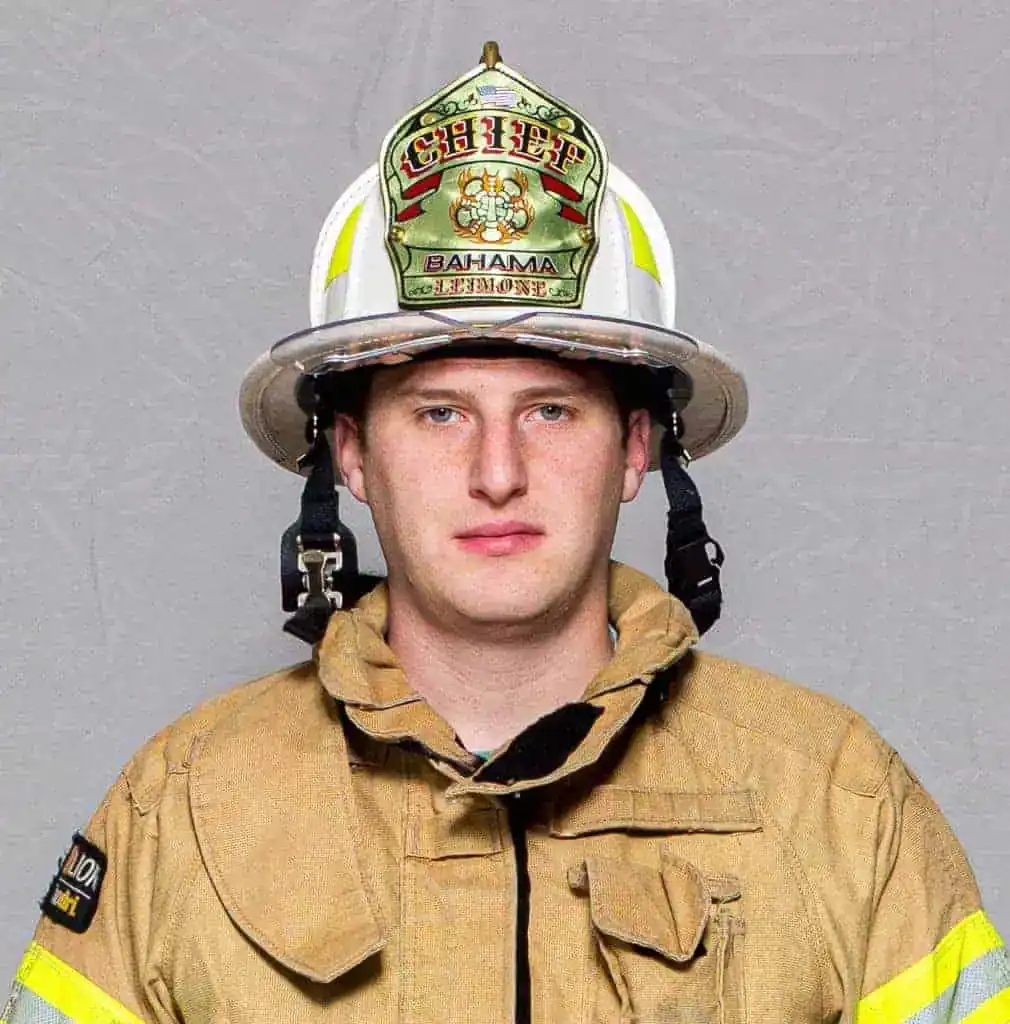 Cole Leimone, Fire Chief of the Bahama Volunteer Fire Department, standing in uniform in front of a fire engine.