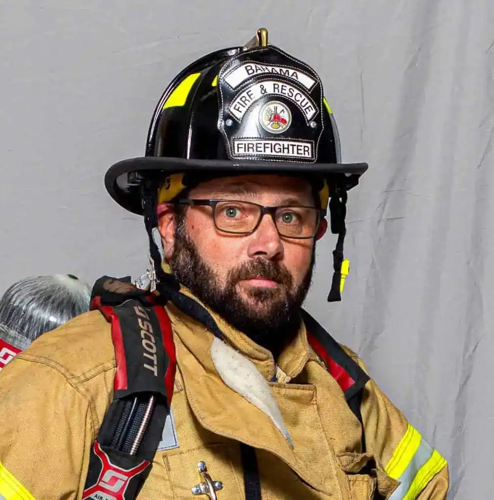 Brian Eaton, Assistant Chief of the Bahama Volunteer Fire Department, in full turnout gear and helmet labeled “Asst. Chief 103,” posing against a neutral background.