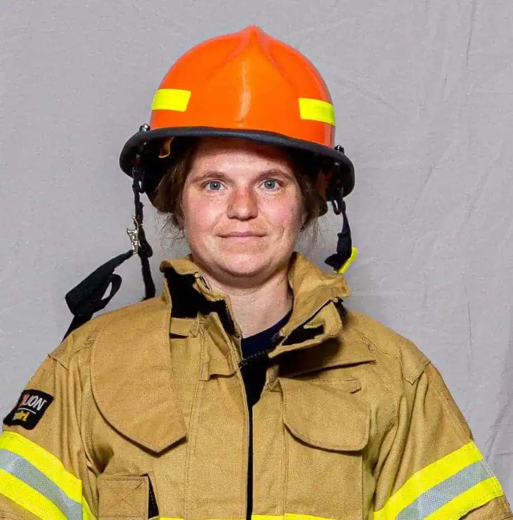 Kristina Jennette, EMT with the Bahama Volunteer Fire Department, wearing full turnout gear and an orange helmet, facing forward in a professional portrait.